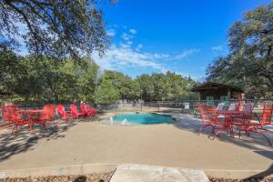 a group of red chairs sitting around a pool at Wimberley Log Cabins Resort and Suites- Unit 8 in Wimberley
