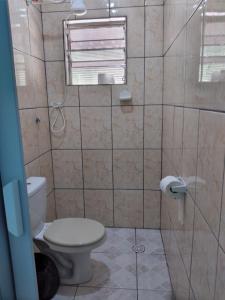 a bathroom with a toilet and a shower at Pedacinho do Paraiso in Mongaguá