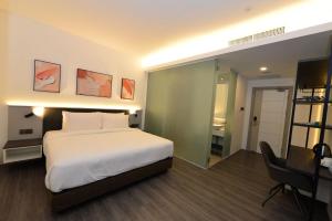 a hotel room with a bed and a desk and a desk at Rume Hotel in Kuching