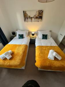 ミルトン・キーンズにある4 Bed spacious property Max 8 Sleepsのベッド2台(タオル付)が備わる客室です。