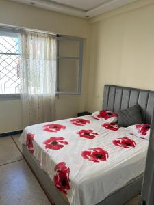 - une chambre avec un lit orné de roses rouges dans l'établissement Superbe appartement Patio, à Rabat