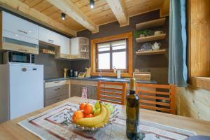 a kitchen with a bowl of fruit and a bottle of wine at Villa Triti in Stará Lesná