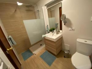 een badkamer met een douche, een wastafel en een toilet bij Vivir La Vida in Cala Ratjada