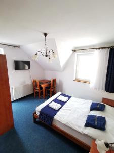 a bedroom with a bed and a table and a window at Grodzisko pokoje do wynajęcia in Krynica Morska