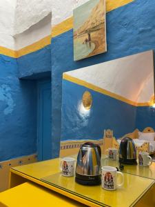 a table with two coffee pots and cups on it at Nubian palace in Aswan