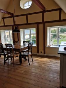 a dining room with a table and chairs and windows at Møllehusets Bed & Breakfast in Nordborg