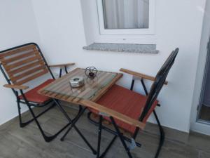 uma mesa e duas cadeiras sentadas ao lado de uma janela em Studio Apartment - Prizren em Prizren