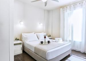 een witte slaapkamer met een bed met een laptop erop bij Villa Iremia in Platithriás
