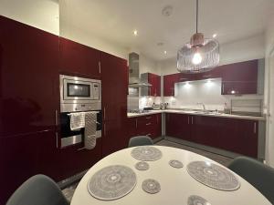 a kitchen with a table with chairs and a microwave at 2 Bedroom House with Garden Next to River Tees in Stockton-on-Tees