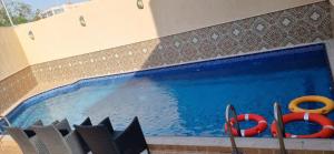 a swimming pool with two red life savers and twoicans at Luxury villas for rent in Jeddah