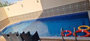 a swimming pool with two red life savers and twoicans at Auris Alfanar Villa Hotel in Jeddah