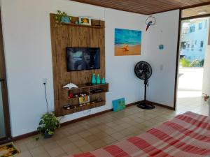un soggiorno con TV e ventilatore di Apartamento em Canasvieiras perto do mar a Florianópolis