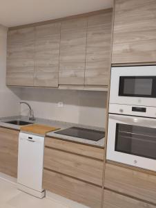 una cocina con electrodomésticos blancos y armarios de madera en PISO CENTRO - CONCORDIA, en Ourense
