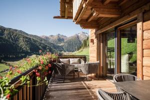 balcón con mesa, sillas y montañas en Chalet Brunegg, en Rio Bianco