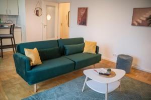 uma sala de estar com um sofá verde e uma mesa em RR - Modern Apartment 53qm - Balcony - Lift em Magdeburgo