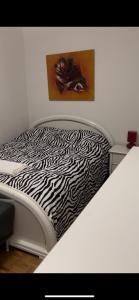 Una cama blanca con sábanas estampadas de cebra. en Appartement Montreux, en Montreux