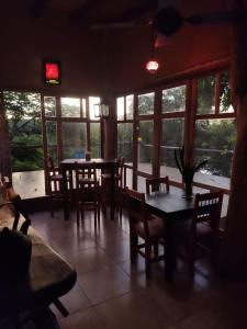 a dining room with tables and chairs and windows at Parana Inn in Puerto Iguazú