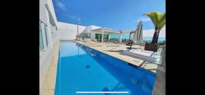 a swimming pool with chairs and umbrellas next to the ocean at Flat hotel saint moritz in Brasilia