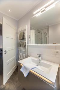 ein Bad mit einem Waschbecken und einem Spiegel in der Unterkunft Südernest 2 in Wyk auf Föhr