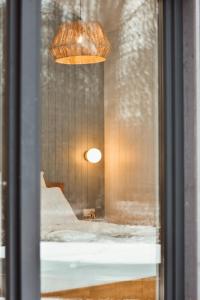 eine Reflexion eines Zimmers in einem Fenster mit Licht in der Unterkunft Poilsio nameliai - B E L A I K O in Kretinga