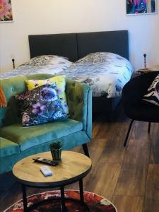 ein Wohnzimmer mit einem Sofa und einem Bett in der Unterkunft B &B Yuupke Maasbree Noord-Limburg Venlo Roermond in Maasbree