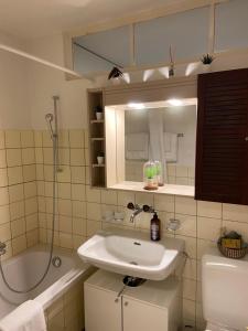 a bathroom with a sink and a toilet and a tub at Comfort 1 and 2BDR Apartment close to Zurich Airport in Zurich