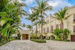 a courtyard with palm trees in front of a building at Marco Beach Ocean Resort 607 in Marco Island