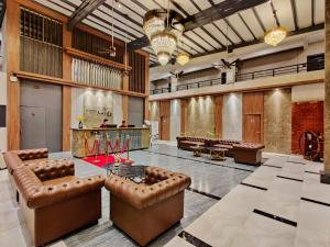 een grote lobby met lederen meubels en een bar bij Pushpam Lords Resort Karjat- Pure Veg in Karjat