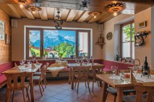 a restaurant with tables and a large window at Gasthof Und Hotel Maria Gern in Berchtesgaden