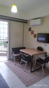 a room with a table and chairs and a television at Flat Quartier - Aldeia das Águas in Barra do Piraí