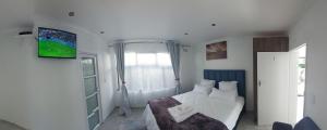 ein weißes Schlafzimmer mit einem Bett und einem Fenster in der Unterkunft Blue Nile Guest in Kapstadt