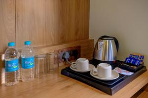 een aanrecht met 2 flessen water en een koffiezetapparaat bij Metropolis Business Hotel in Panaji