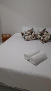 Una cama blanca con dos toallas plegables. en Pousada Sossego do Pirata en Arraial d'Ajuda