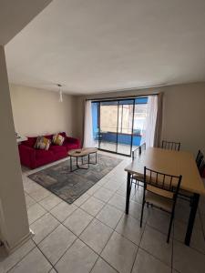 a living room with a red couch and a table at 3D 2B cerca playa y centro, Park Surf in Iquique