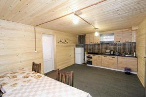 Habitación con mesa y cocina con paredes de madera. en Alpiyske Shale en Yablunytsya
