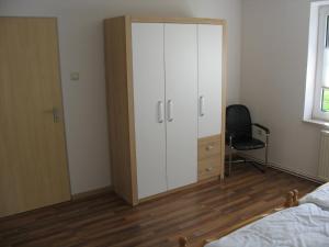 パーペンブルクにあるHaus Eichengrundのベッドルーム(白い大型キャビネット、椅子付)