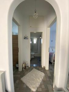 a hallway with a white rug and a bathroom at Molos Sea View House - Paros Greece in Molos Parou