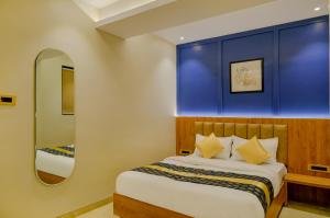 una camera con un letto con una parete blu di Metropolis Business Hotel a Panaji
