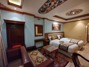 a hotel room with two beds and a living room at Sherpa Home Hotel in Kathmandu