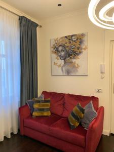 a red couch in a living room with a painting at Schillerplatz Apartment in Sibiu