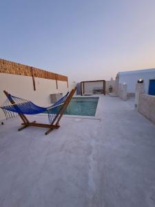 a hammock on a patio next to a swimming pool at Houche djerbien in Mezraya