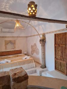 a bedroom with a bed and a light on the ceiling at Houche djerbien in Mezraya