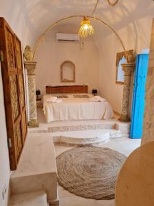 a bedroom with a large bed with a large rug at Houche djerbien in Mezraya