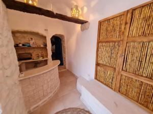 a bathroom with a shower and a wooden door at Houche djerbien in Mezraya