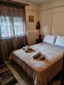 1 dormitorio con 1 cama grande y 2 toallas. en Σπίτι στη Γωνία, en Tríkala