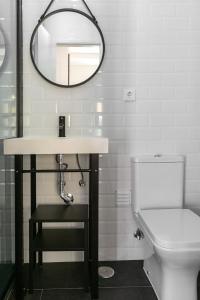 une salle de bain avec un lavabo et un miroir et des toilettes dans l'établissement Old Town House, à Peniche 9 autres photos