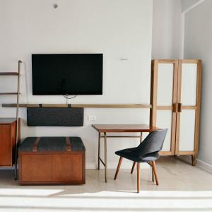a living room with a chair and a television on a wall at Mex Hoteles in Cancún