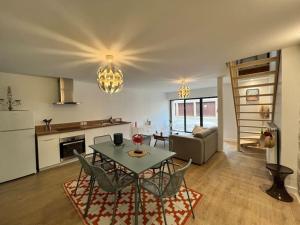 cocina y sala de estar con mesa y sillas en A 5mn du Futuroscope: Loft ravissant!, en Jaunay-Clan
