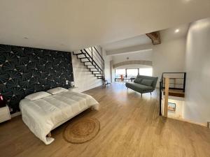 1 dormitorio con 1 cama, 1 silla y una escalera en A 5mn du Futuroscope: Loft ravissant!, en Jaunay-Clan