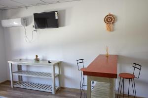 Habitación con mesa y TV en la pared. en Aparts ALDEA DEL MONTAÑES en Mina Clavero